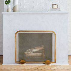 a white fireplace with gold trim and a painting on the mantle