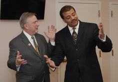 two men standing next to each other in suits