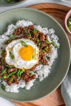 a green plate topped with rice and an egg