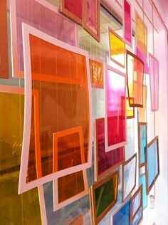 a wall that has many different colored frames on it