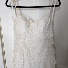 a white dress hanging on a hanger in front of a door with an open window