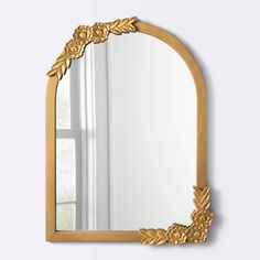 an ornate gold framed mirror on a white wall