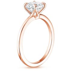 a rose gold engagement ring with a princess cut diamond in the center, on a white background