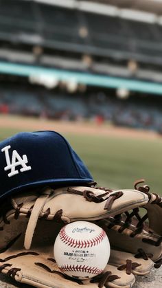 a baseball mitt with a cap on top of it and a ball in the glove