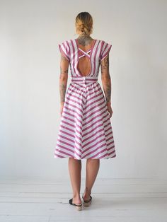 "Vintage 80's chevron striped sundress. Adjustable tie at waist. Open back with buttons down lower back. Full skirt. Lightweight cotton material. - - M E A S U R E M E N T S - - Fits like: xs/small Bust: 17\" Waist: 13\"-adjustable smaller Length: 44\" Hips: open Shoulder: 14.5\" Fabric: cotton In excellent condition - no flaws to note. ● Model is 5'7\" / bust: 34\" / waist: 25\" / hips: 37\"" Striped Fitted Sundress For Summer, Fitted Striped Sundress For Summer, Fitted Summer Dress With Vertical Stripes, Striped Fitted Midi Sundress, Cotton Dress With Vertical Stripes For Day Out, Striped Summer Daywear Dress, Striped Summer Dresses For Daywear, Striped Summer Dress For Daywear, Pink Vertical Stripe Summer Dress