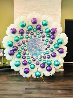 a large balloon decorated with purple and green balloons in the shape of a peacock's nest