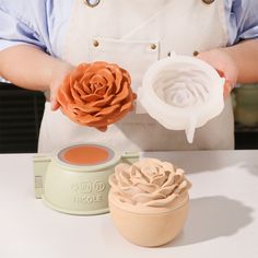 a person holding two flower molds in their hands