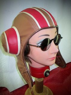 Custom made-to-order genuine leather aviator inspired by the Psychonauts/ Razputin videogames.  Super- soft brown and red lambskin leather with comfy quilted lining and foam- padded earcups.  Solid brass buckle and brown goggle holder button.   Features "tunnels" under earcups for your goggle straps to pull through to back of hat.  This listing is for a 'MADE TO ORDER" Leather Razputin Aviator!  Turnaround time is 2-3 weeks(excluding ship time) upon purchase.  PLEASE give your exact head size(see diagram), and any special instructions regarding color changes for leather/ hardware.  Care:  Apply leather conditioner twice a year. Dry- cleaning NOT recommended!  If soaked wet, air- dry away from direct sun or heat sources. "Leatherhead" is the only known person(me) that makes Razputin's aviat Retro Brown Leather Hat, Aviator Hat, Leather Gear, Pull Through, Leather Conditioner, Brass Buckle, Nov 6, Lambskin Leather, Vintage Leather