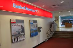 the bank of america sign is on the wall in front of the stairs to the lobby