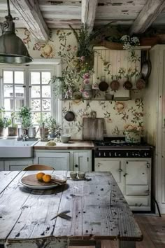 a kitchen with an old wooden table in the center and hanging pots on the wall