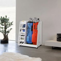 a white shelf filled with luggage next to a tree in a modern living room area