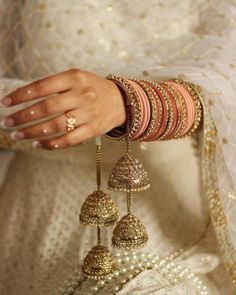 a close up of a person wearing bracelets and rings