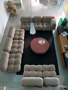 an overhead view of a living room with couches and coffee table in the center