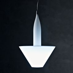 a white light hanging from the side of a black wall