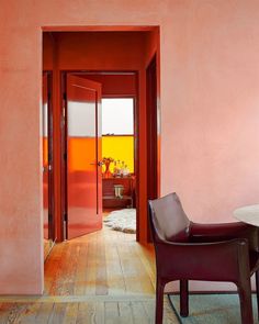 a chair and table in a room with pink walls on either side of the door