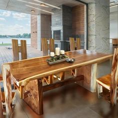 a wooden table with candles on it in front of a large window overlooking the water