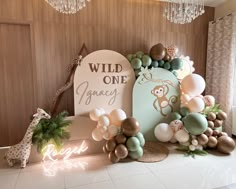 an animal themed birthday party with balloons and decorations on the wall, including a sign that says wild one gracey