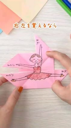 someone is holding up an origami piece with a drawing of a ballerina on it