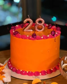 an orange birthday cake with the number 28 on it