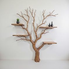 a wooden tree shelf with two vases on it's sides and shelves below