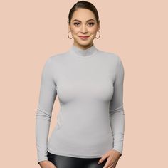 Indulge in the opulent coziness and effortless elegance of our newly updated mock neck. Featuring a sleek and refined neckline, it now comes in 10 stunning hues. Crafted from luxurious Italian 4 way stretch microfiber fabric, it delicately cascades over the figure and eliminates clinginess when layered with other garments. An essential piece for your autumn and winter collection, this top can be worn alone for a striking look or layered under sweaters or jackets.