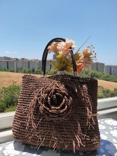 Discover the unique elegance of our handcrafted brown straw bag,  woven from eco-friendly paper yarn and designed to make a statement. This beautiful accessory combines natural materials with refined details, featuring a charming rose motif and durable faux leather handles, making it a perfect addition to your wardrobe for any occasion. Made from high-quality, eco-friendly paper yarn, this bag is designed in a rich brown color that pairs perfectly with any outfit. It features a classic, minimali Eco-friendly Brown Straw Basket Bag, Brown Crochet Beach Bag With Weaving, Brown Crochet Beach Bag With Weaving Detail, Brown Weaving Crochet Beach Bag, Brown Weaving Straw Bag For Daily Use, Brown Weaving Straw Bag For Beach, Handmade Brown Straw Bag, Handmade Brown Basket Straw Bag, Summer Brown Straw Bag With Weaving