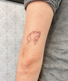 a woman's arm with a small tattoo of a hand holding a flower on it