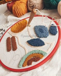 a close up of a embroidery on a table with yarn and crochet hooks