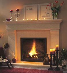 a living room with a fire in the fireplace and candles on the table next to it