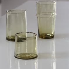 three glasses sitting on top of a white table