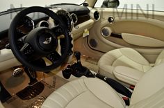 the interior of a car with white leather seats and steering wheel, including an automatic