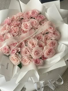 a bouquet of pink roses is wrapped in white paper