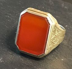 "Classic 14k yellow gold ring, rectangular bezel set Carnelian (16 by 13mm), with terrific hand engraved setting, strong good looking design.  Size 7 3/4, wt.-  4.3 grams.  Top of ring approx. 3/4\" north to south on finger.  Classic shape and easy to wear.  Circa 1920-30.  good condition, clean design, any wear commensurate with age and slight, Photos show details." Rectangular 14k Stamped Signet Ring Collectible, Classic Carnelian Signet Ring For Formal Occasions, Classic Carnelian Signet Ring For Formal Events, Elegant Gold Signet Ring With Carnelian, Rectangular Cabochon Yellow Gold Ring, Red Rectangular Ring With Polished Finish, Gold Rectangular Cabochon Rings, Rectangular Gold Cabochon Rings, Rectangular Cabochon Gold Rings