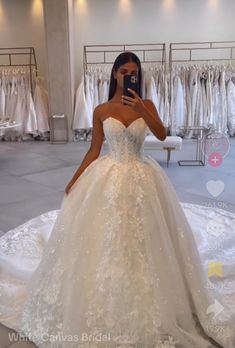 a woman is taking a selfie in her wedding dress at the bridal shop