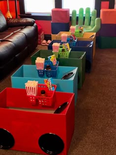 several colorful boxes with food in them sitting on the floor next to a black couch