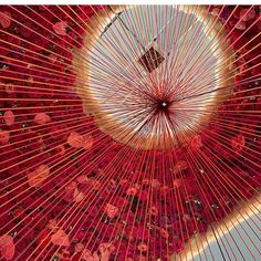 the inside of a large red object with many strings hanging from it's center