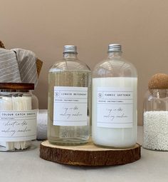 three bottles are sitting on a table next to some soaps and other bath products