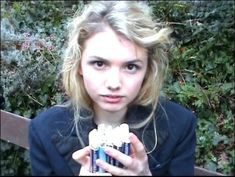 a young woman holding up a can of soda