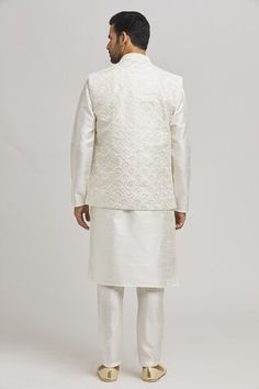 Cream bundi featuring thread embroidered peacock patterns with sequin work embellishments. Paired with an inner kurta and pant., Fit: Relaxed Art Silk Bandhgala With Chikankari Embroidery For Festive Occasion, Festive Art Silk Bandhgala With Chikankari Embroidery, Elegant Chanderi Nehru Jacket For Diwali, Eid Raw Silk Nehru Jacket With Chikankari Embroidery, Eid Nehru Jacket In Raw Silk With Chikankari Embroidery, Chanderi Bandhgala With Chikankari Embroidery For Wedding, Unstitched Festive Nehru Jacket For Reception, Festive Designer Nehru Jacket With Chikankari Embroidery, Elegant Bandhgala With Chikankari Embroidery For Navratri