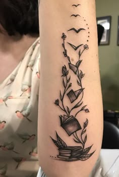 a woman with a tattoo on her arm has a book and flowers growing out of it