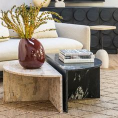 a living room filled with furniture and a large vase on top of a coffee table