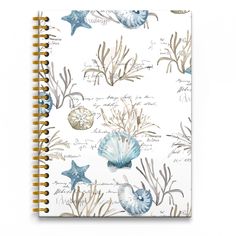 a spiral notebook with shells and starfishs on it