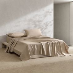 a bed sitting in the middle of a room next to a wall with white walls