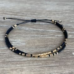 Bead And Cord Bracelet, Minimalistic Beaded Jewelry, Gold Adjustable Double Strand Beaded Bracelets, Black Dainty Friendship Bracelets As Gift, Black And Gold Beaded Bracelets, Dainty Black Friendship Bracelets As Gift, Dainty Black Friendship Bracelets For Gifts, Elegant Black Friendship Bracelets, Elegant Black Friendship Bracelet