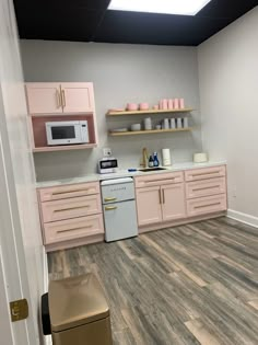 the kitchen is clean and ready for us to use it's pink cabinets are next to the stove