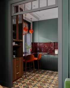 an open door leading to a kitchen with green walls and colorful tile on the floor