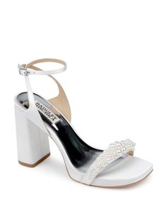 a white high heeled shoe with pearls on the ankle and an ankle strap,