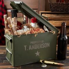 a green box filled with bottles and wine on top of a wooden table next to a bottle