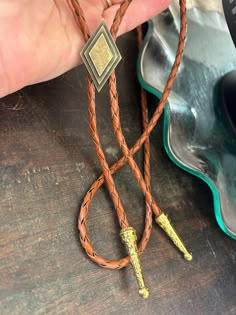 This awesome bolo tie has a metal diamond design. The cord is genuine brown leather. Our bolos pair nicely with many of our belt buckles! They make wonderful gifts.    The western bolo tie rope length is 39'' ; charm pendant size is 1 1/4'' tall