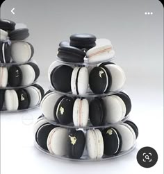 two stacks of black and white macaroons sitting on top of each other